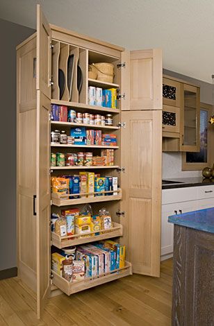 an organized pantry in the middle of a kitchen with wooden flooring and cupboards