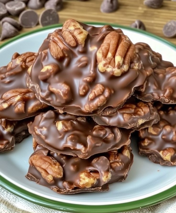 chocolate pecan cookies stacked on top of each other with walnuts in the background