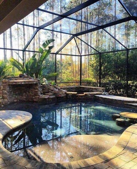 an indoor swimming pool in the middle of a patio area with seating and a fire pit