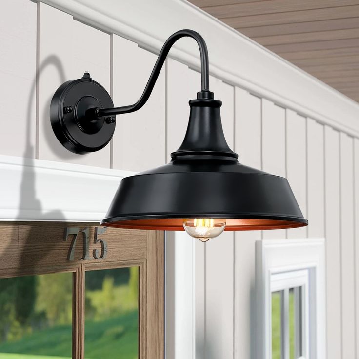 an outdoor light hanging from the side of a house with white siding and wood paneling