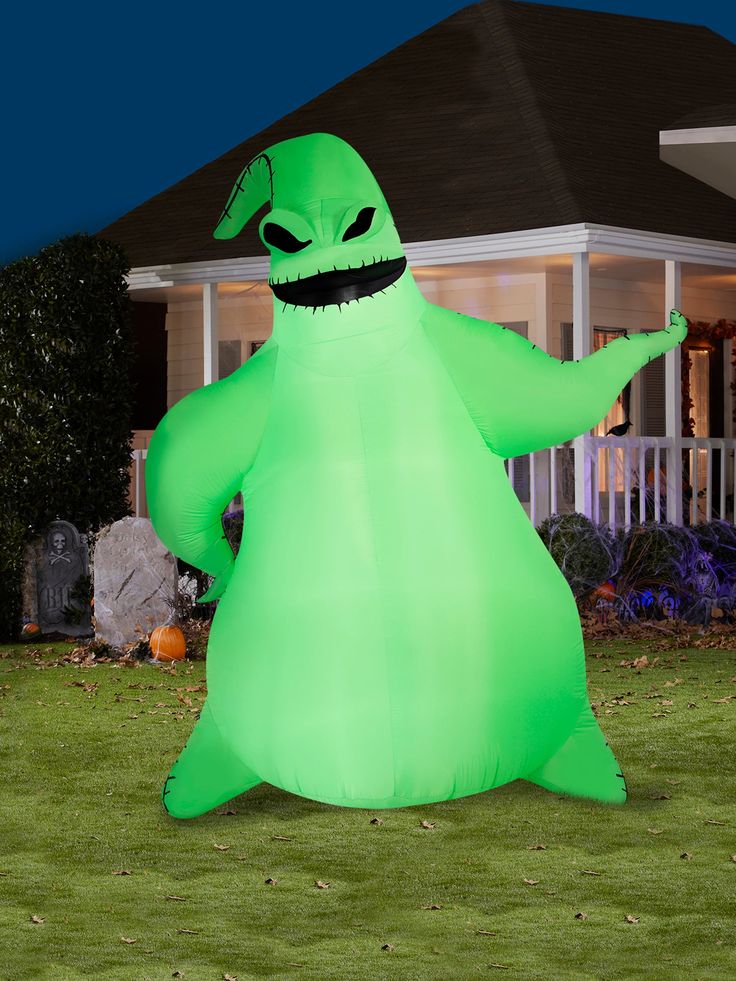 an inflatable green ghost standing on the lawn