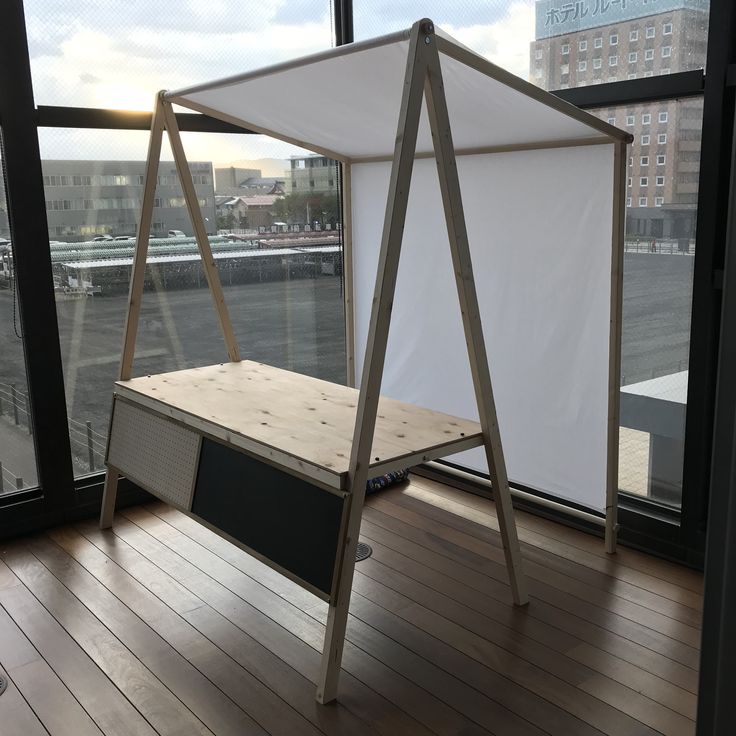 a bed frame sitting on top of a hard wood floor next to a large window