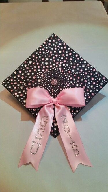 a decorated graduation cap with pink ribbon