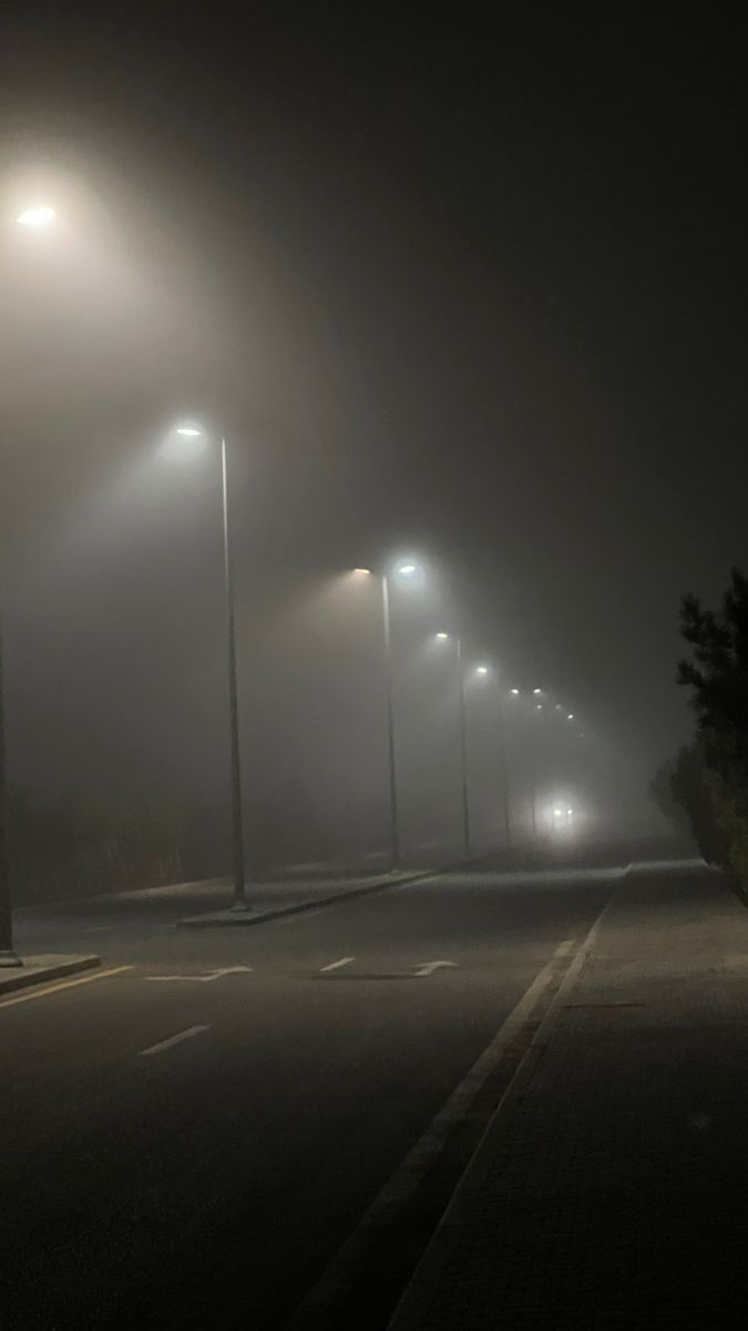 street lights on a foggy night with no one in the photo looking at them