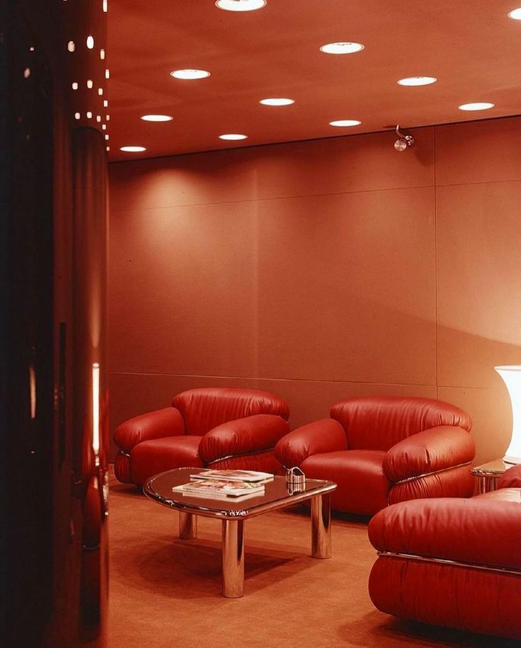 a living room filled with red leather furniture