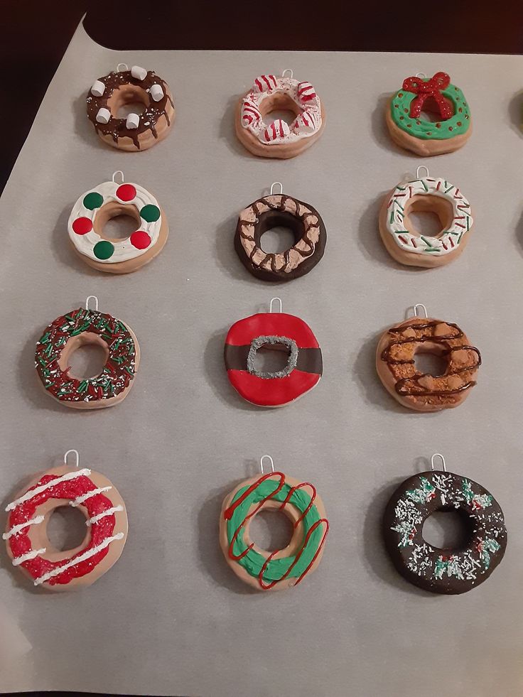 twelve decorated doughnuts sitting on top of a tray