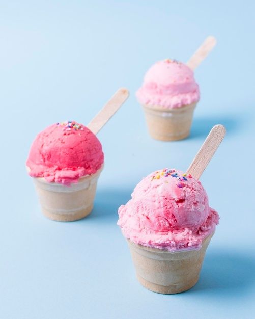 three scoops of ice cream with sprinkles in them on a blue background