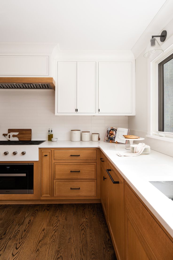 a kitchen with wooden cabinets and white counter tops