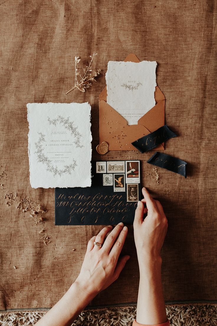 a person is writing on an envelope surrounded by other items