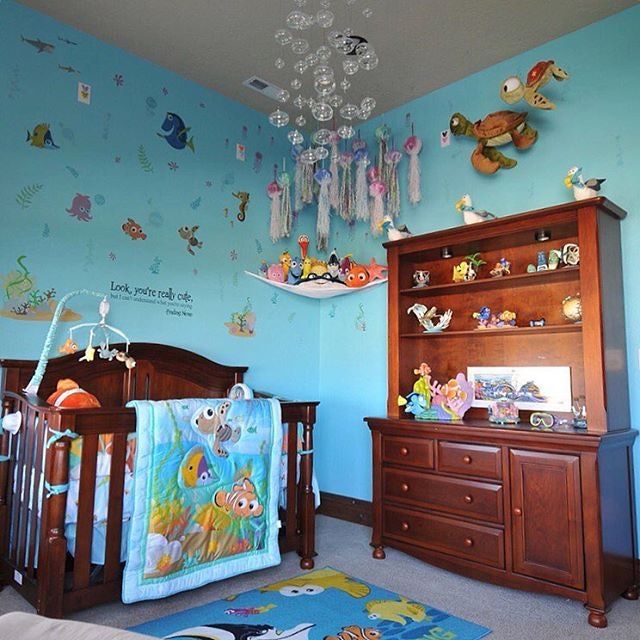 a baby's room decorated in blue and brown with lots of toys on the wall