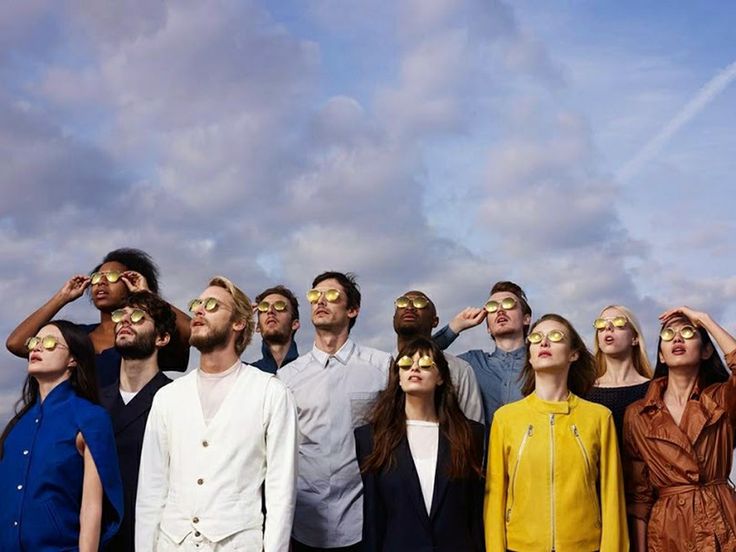 a group of people standing next to each other with their eyes covered by sun glasses