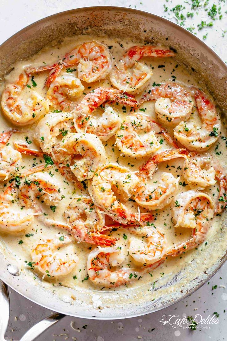 a skillet filled with shrimp and grits on top of a white countertop