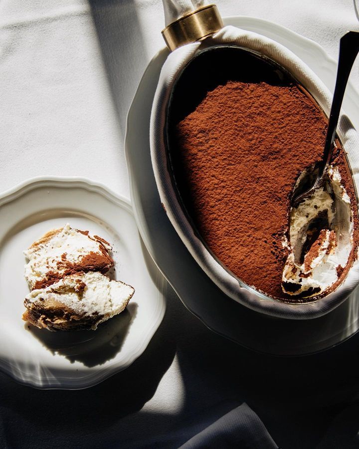 there is a desert in the bowl on the table with a spoon next to it