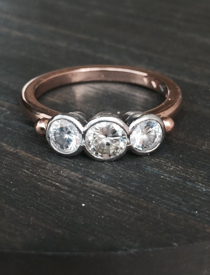 three stone ring sitting on top of a wooden table