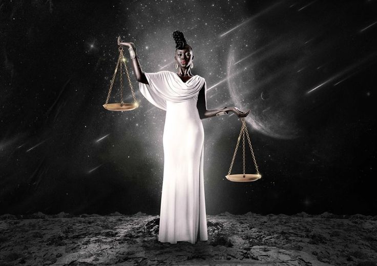 a woman holding two scales in her hands and standing on the moon with stars behind her