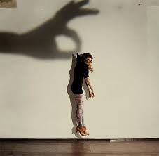 the shadow of a person's hand is cast on a wall as if they were dancing