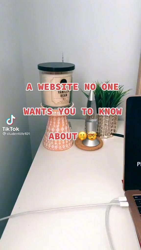 an open laptop computer sitting on top of a white desk next to a potted plant