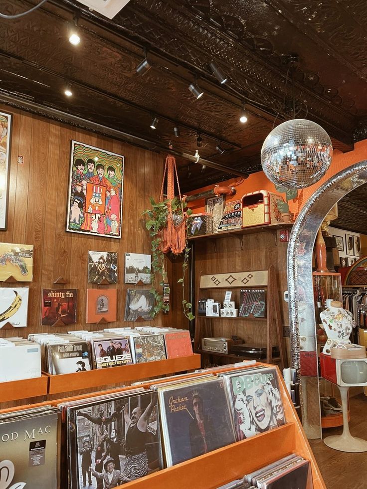 the inside of a record store with various records on display and mirrors hanging from the ceiling