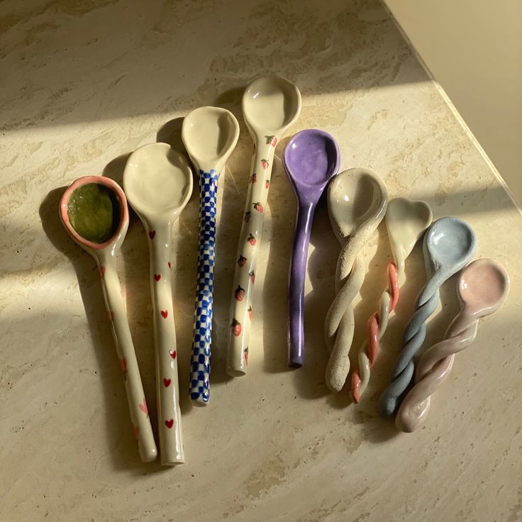 six spoons lined up on a counter top