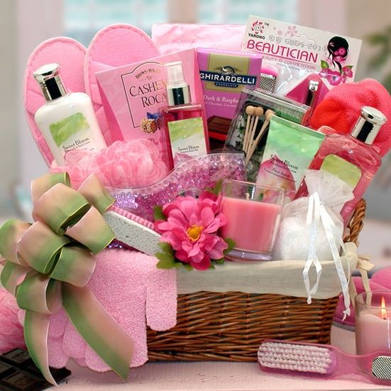 a pink gift basket filled with personal care items and candles for someone's birthday