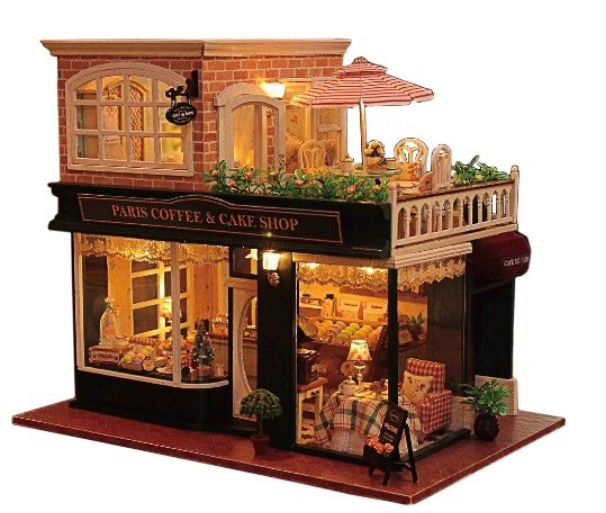 a doll house with lights and furniture on the outside, in front of a store