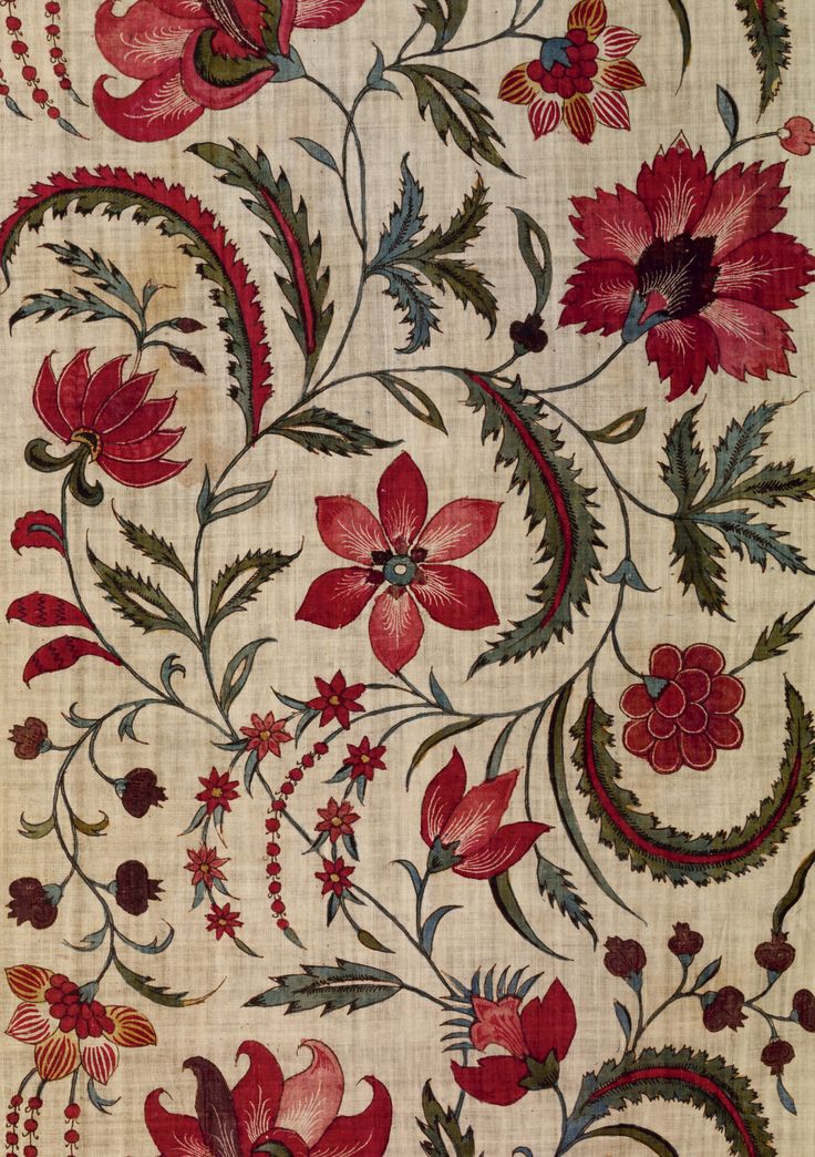 an old rug with red flowers and leaves on it