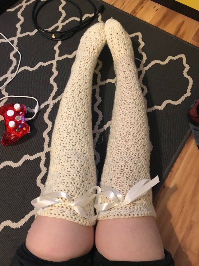 the legs of a woman wearing white socks and stockings with bows are on a rug