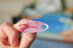 a person holding a pink feather in their hand