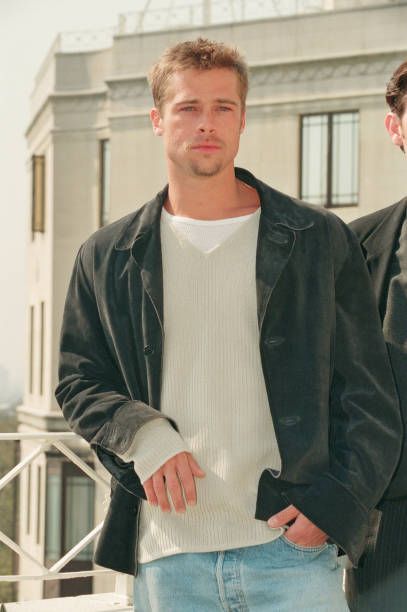 two men standing next to each other in front of a building and looking at the camera