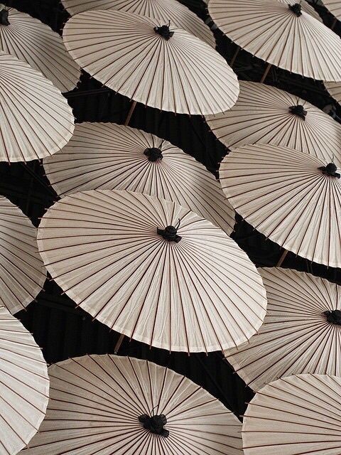 many yellow parasols are arranged in rows on the ground, with black background