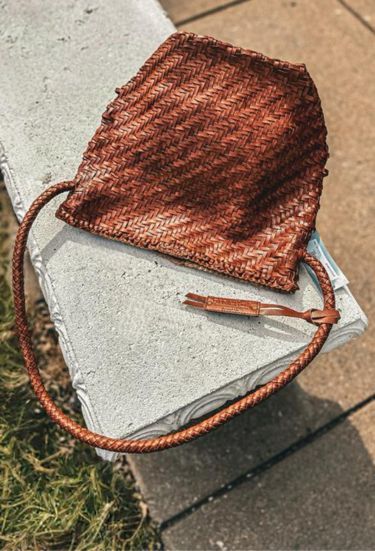 a brown bag sitting on top of a cement bench