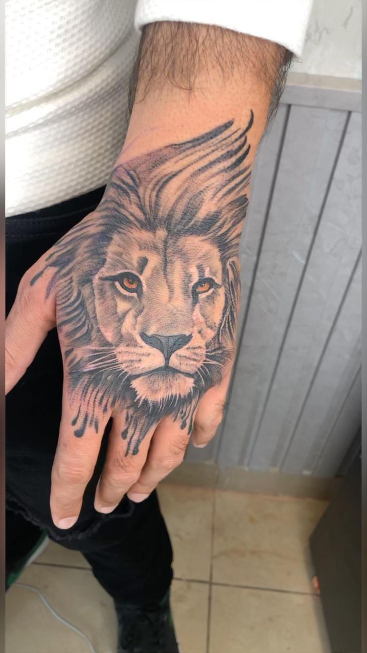 a man's hand with a lion tattoo on it