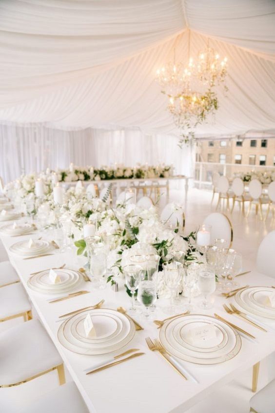 the tables are set with white flowers and place settings