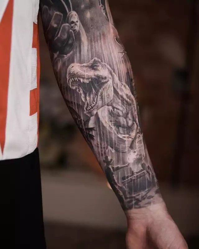 a man with a tattoo on his arm is holding the hand of another person that has a dinosaur