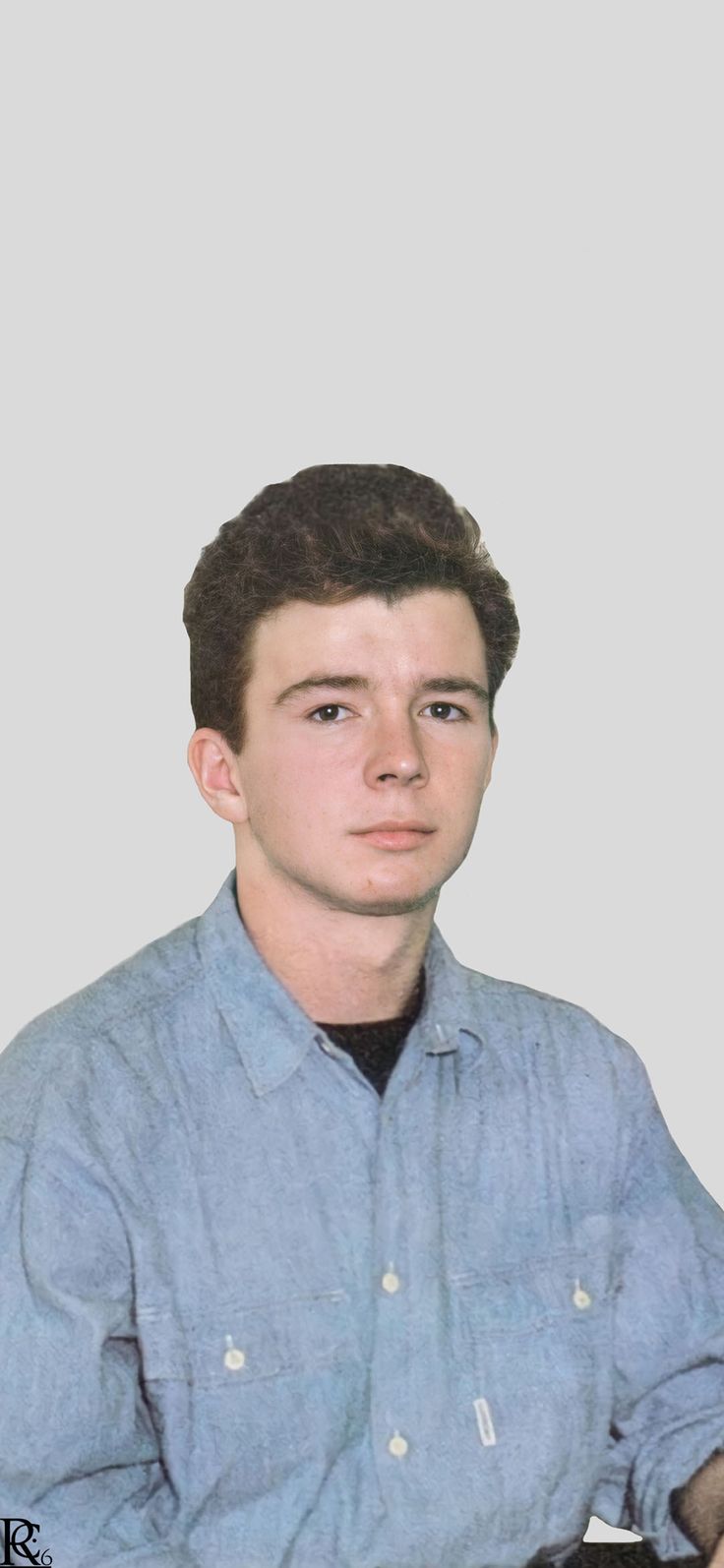 a young man sitting in front of a white wall wearing a blue shirt and black tie