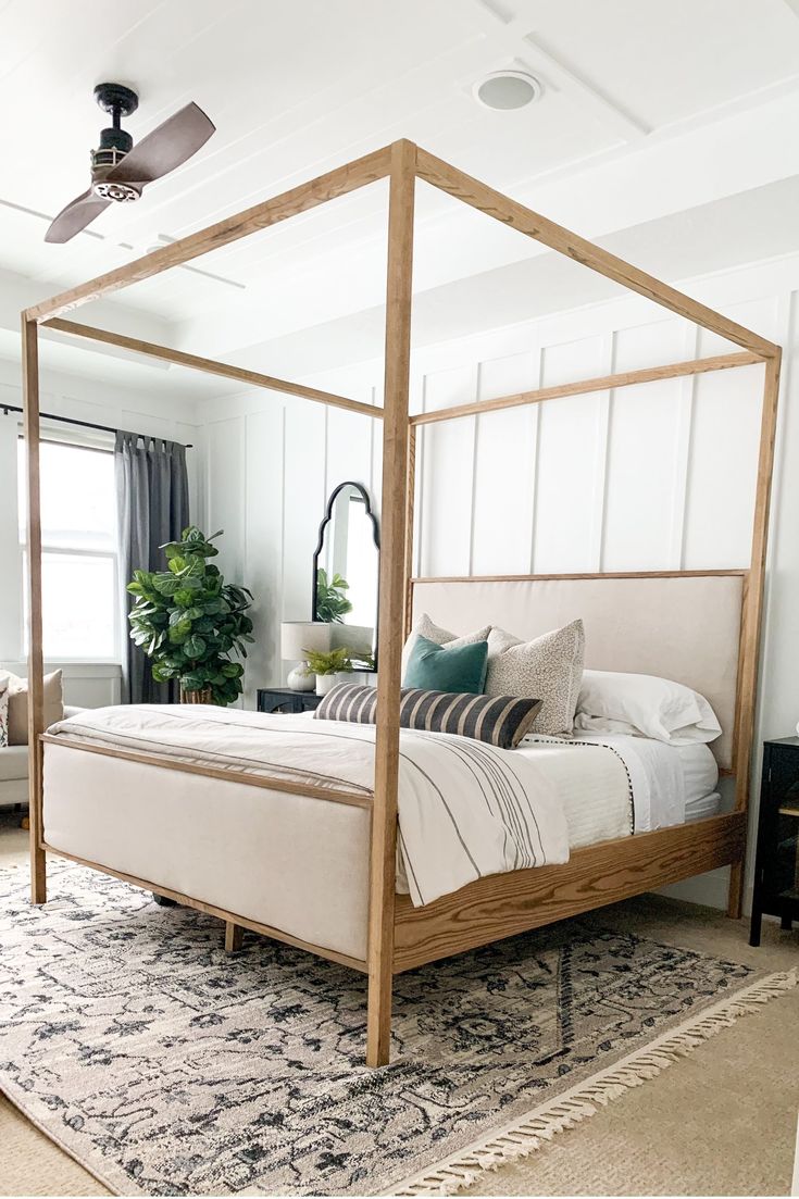 a bedroom with a canopy bed and rugs on the floor in front of it