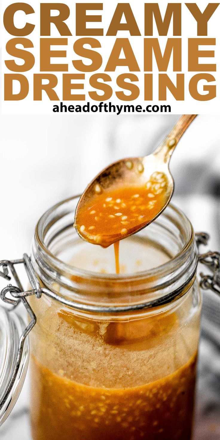 a spoon full of homemade creamy sesame dressing in a jar with the title above it