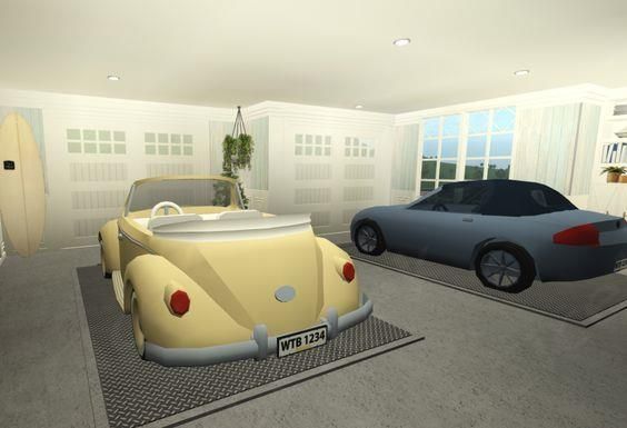 two cars are parked in a room with surfboards on the wall and one is yellow