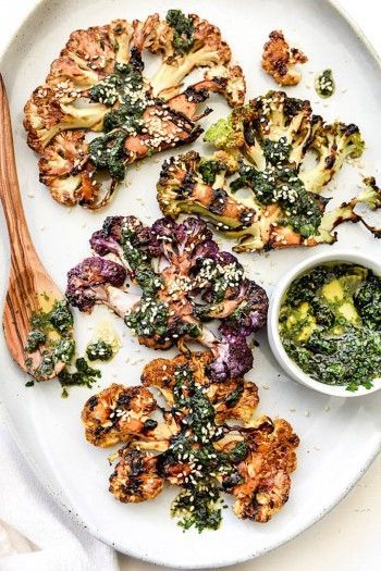 a plate with broccoli, cauliflower and other food items on it