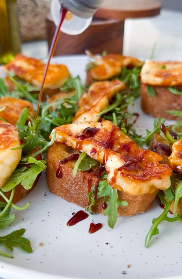 a white plate topped with toasted bread covered in toppings