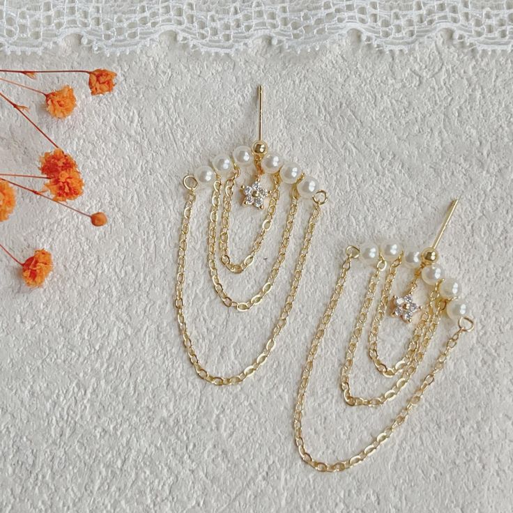 Add a touch of elegance to your look with these delicate pearl tassel chain earrings. With sparkling chains cascading down from delicate pearls, these earrings are perfect for adding femininity and sophistication to any outfit. Whether you're dressing up for a special occasion or adding a chic touch to your everyday look, these earrings are sure to turn heads. Meticulously handcrafted, these earrings are a must-have addition to your jewelry collection. ✨Product Details 𖧹 Base Metal: Sterling Silver (S925) 𖧹 Plating: 14K Yellow Gold 𖧹 Two studios (New York and Florida): Handcrafted in NY Studio ✨Our jewelry is packaged in an ornament box or envelope. To avoid waste, usually more than one item will be placed in the same box. If you would like your items to be boxed separately, please spec Delicate Gold Hoop Earrings For Party, Gold Dangle Hoop Earrings For Wedding, Dainty Pearl Chain Earrings For Wedding, Delicate Gold Hoop Earrings For Wedding, Delicate Yellow Gold Hoop Earrings For Wedding, Gold Plated Earrings With Pearl Charm For Wedding, Gold Dainty Pearl Earrings For Party, Delicate Dangle Pearl Earrings With Elegant Design, Gold Plated Hoop Earrings With Ear Wire For Wedding