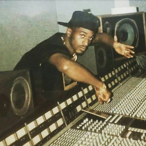 a man leaning over a sound board in a recording studio