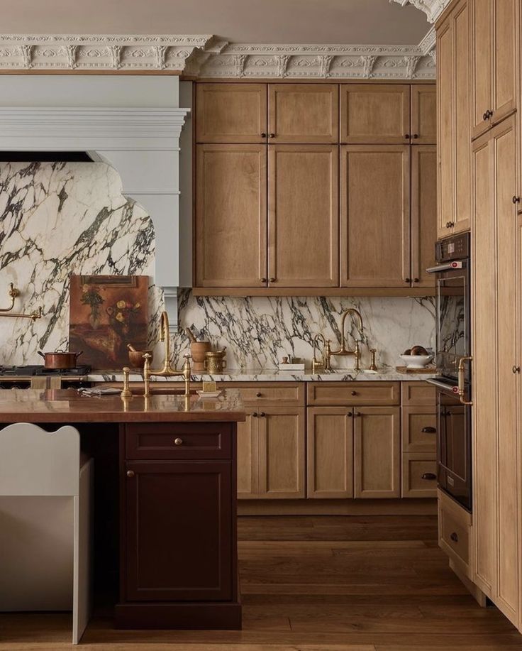 a kitchen with wooden cabinets and marble counter tops, along with an island in the middle