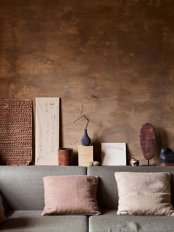 a couch with pillows on it in front of a wooden wall