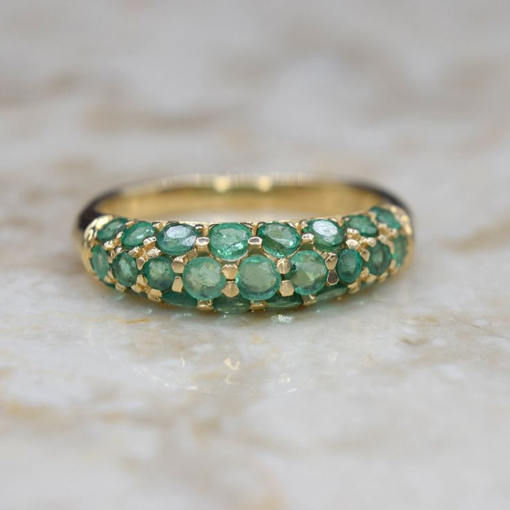 Vintage 14k gold dome-style ring with pave prong-set natural emeralds. The emeralds are bright green with nice translucence.  Era: c.1990s Markings: 14k Materials: 14k gold, natural emeralds (approx. 1.00 ctw) Weight: 2.9 grams Ring Size: 7 (Comes with one free resizing by our jeweler) Condition: Excellent vintage condition with minor surface wear from age Shipping is free in the United States Follow us on Instagram @LUXXORVintage Green Emerald Diamond Ring With Pave Setting, Elegant Domed Emerald Ring, Green Emerald Ring With Pave Setting, Green Emerald Ring With Pave Setting For May Birthstone, May Birthstone Emerald Ring With Pave Setting, Green Dome Ring For Anniversary In Fine Jewelry Style, Gold Emerald Ring With Pave Setting, Gold Emerald Ring With Pavé Setting, Green Emerald Ring With Pave Setting For Anniversary