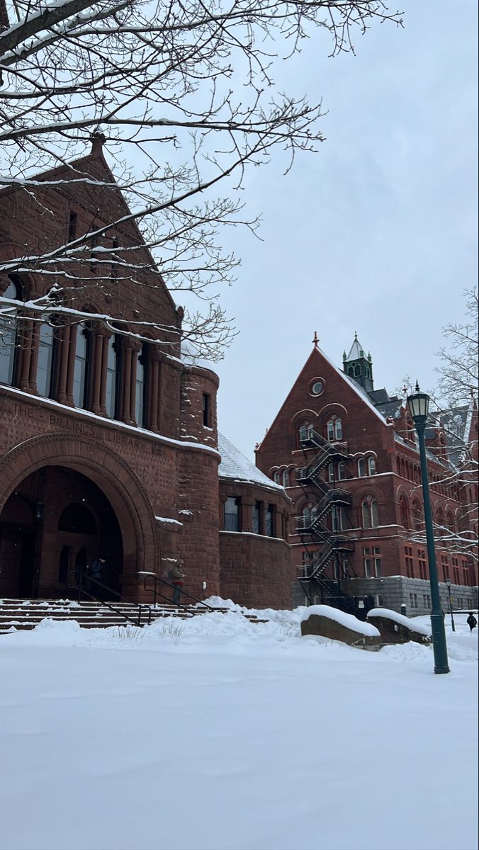 an old brick building with snow on the ground and stairs leading up to it's entrance