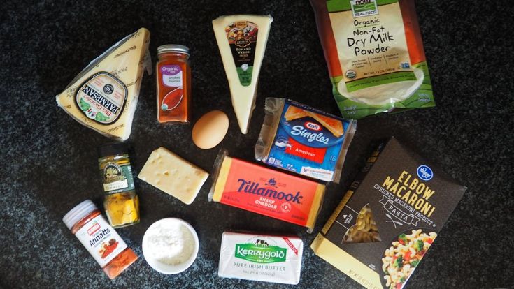 an assortment of cheeses and other food items on a counter