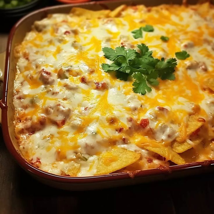 a casserole dish with cheese, meat and veggies in it on a wooden table