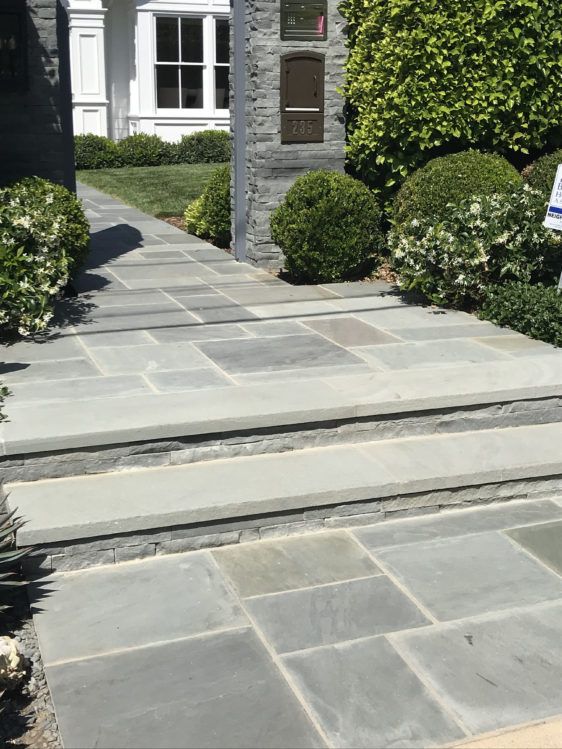 a stone walkway with steps leading to a house