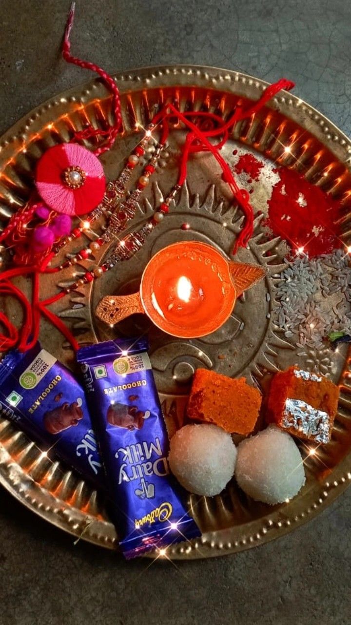 an assortment of chocolates and candy on a metal platter with red string lights